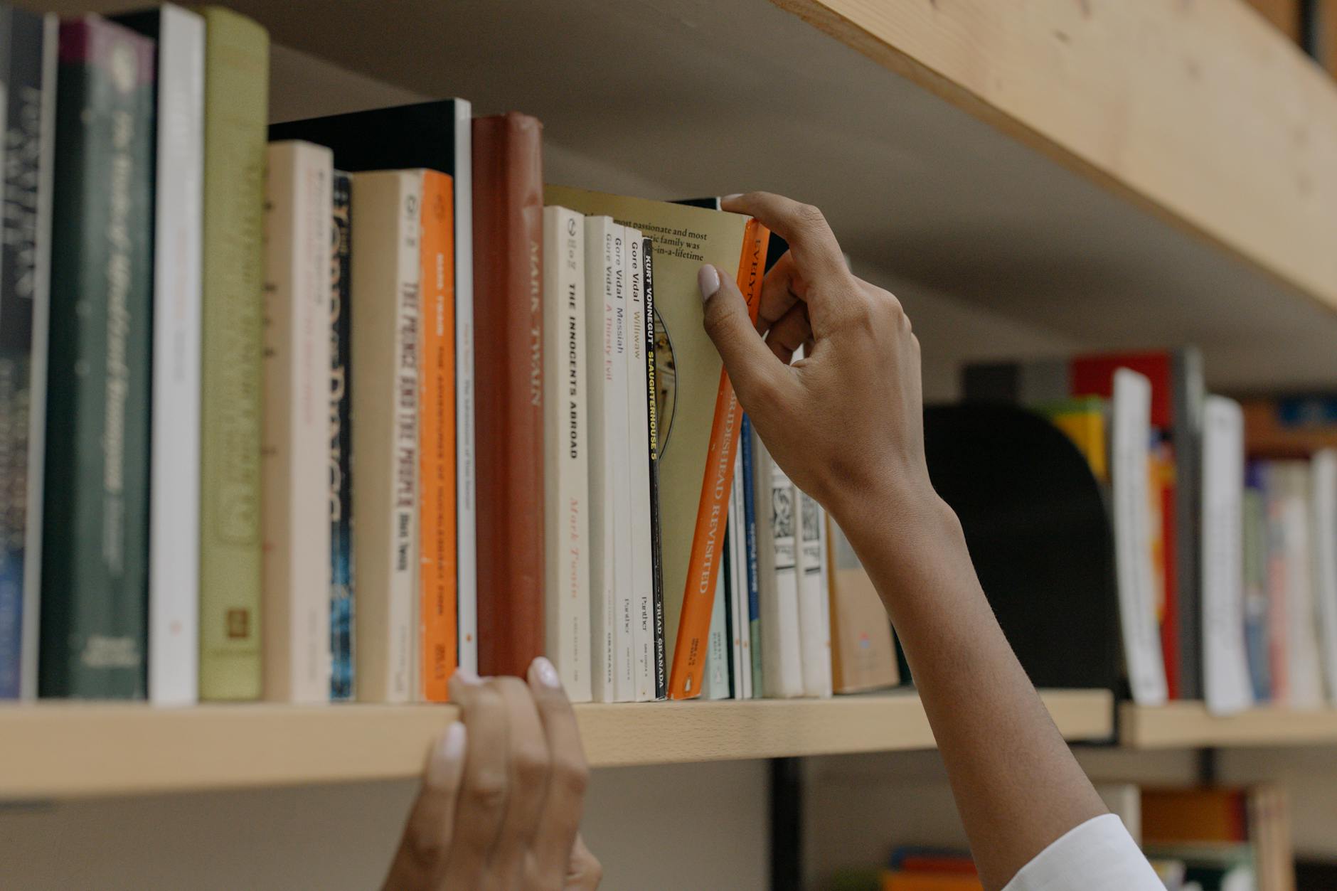 Learner holding study notes in a library setting